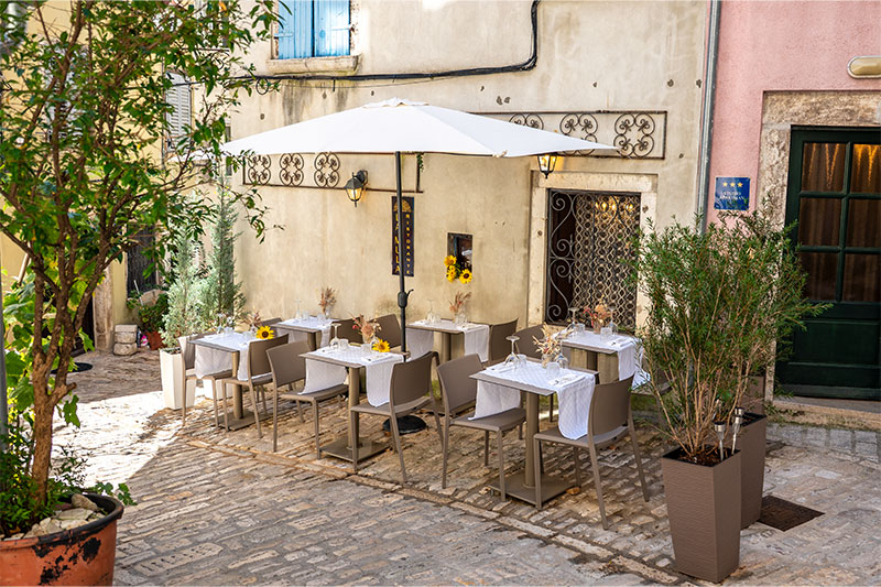 Progetto completo di arredo outdoor e contract per il ristorante La Mula a Rovigno, Croazia, con tavoli, sedute e poltroncine da esterno dal design moderno ed elegante.