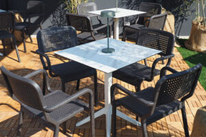 Tavoli quadrati da esterno con base in alluminio Prisma 48 e piano HPL marmo Carrara, eleganti e resistenti per il progetto Stra 2025 a Vicenza.